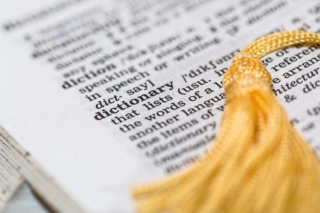 dictionary-reference-book-learning-meaning-159581-159581 Close-up image of a dictionary page focused on the word 'dictionary' with a yellow tassel.