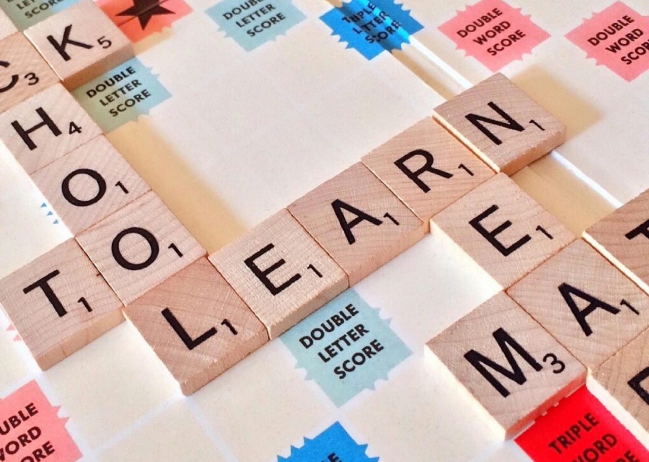 Close-up of Scrabble tiles forming words related to education and school.